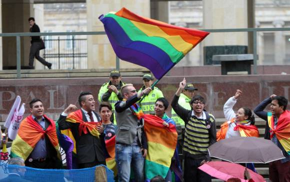 Imagen de manifestantes con una bandera arco iris