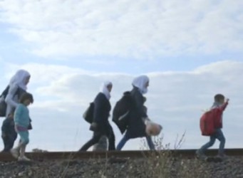 Un grupo de niños y mujeres con pañuelos caminando