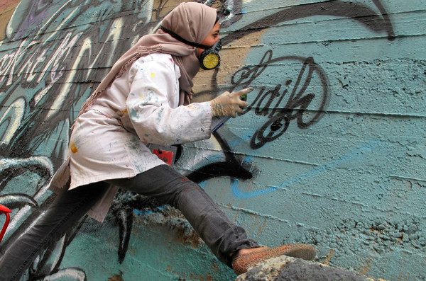 Joven egipcia pintando un graffiti