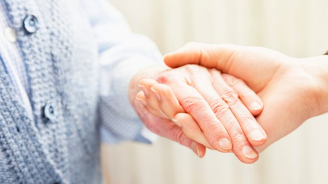 Imagen de las manos de una persona mayor y su cuidadora