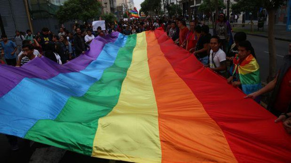 Personas sujetando una bandera LGTBI