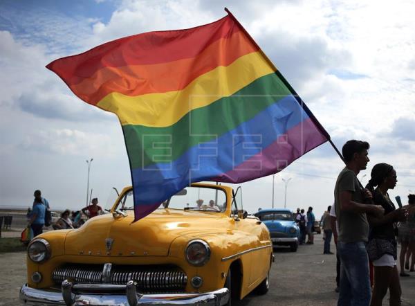 imagen de un joven portando la bandera LGTBI