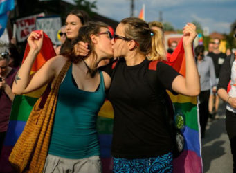 Imagen de dos mujeres besándose en una manifestación