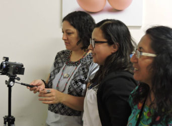 tres mujeres preparando una cámara de fotos