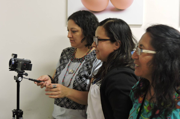 tres mujeres preparando una cámara de fotos