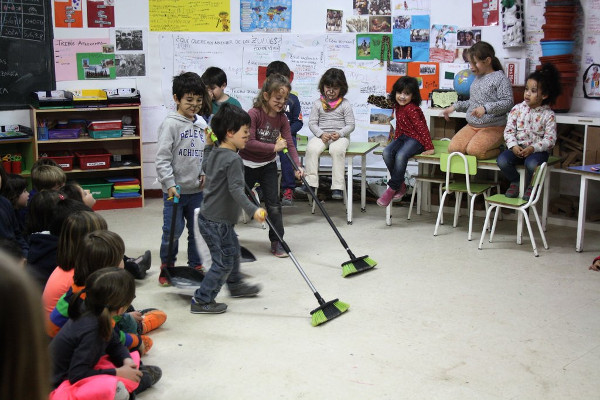 niños y niñas barriendo la clase