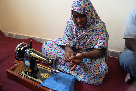 Imagen de una niña en un curso de costura en Mauritania