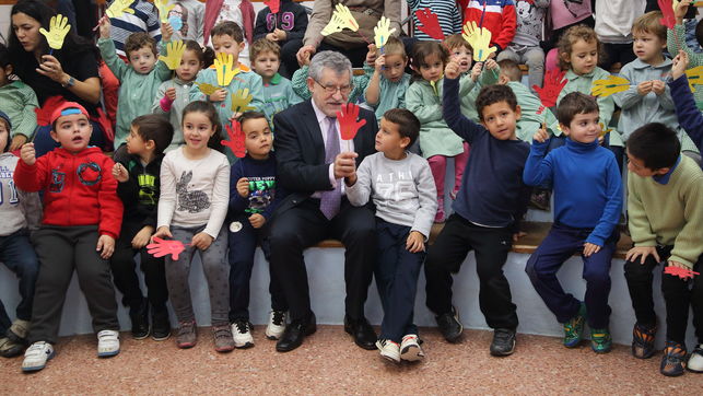 Imagen de un directivo de la Junta con un grupo de niños y niñas