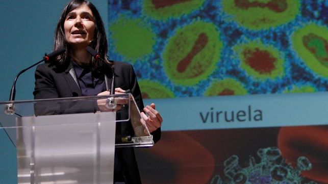 imagen de una científica delante de una diapositiva del virus de la viruela