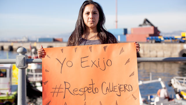 una mujer con una pancarta pidiendo respeto callejero