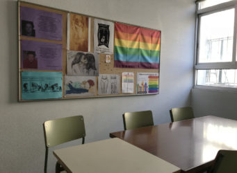 Imagen de un tablón de un aula con la bandera LBTGIQA