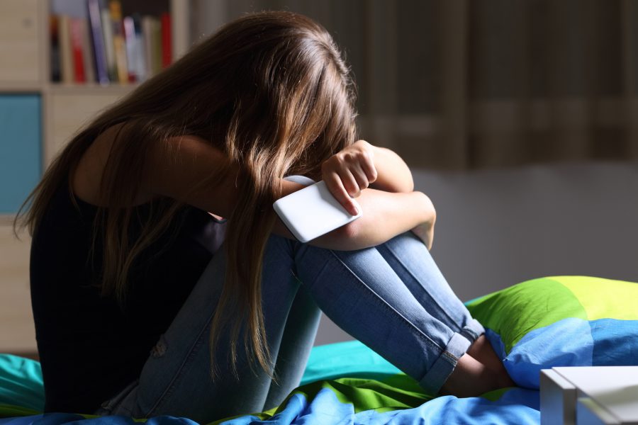 Imagen de una joven de cabello largo con un smartphone en la mano