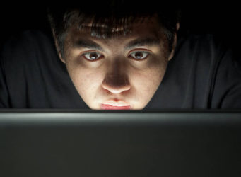 imagen de un joven ante un ordenador con cara de asombro
