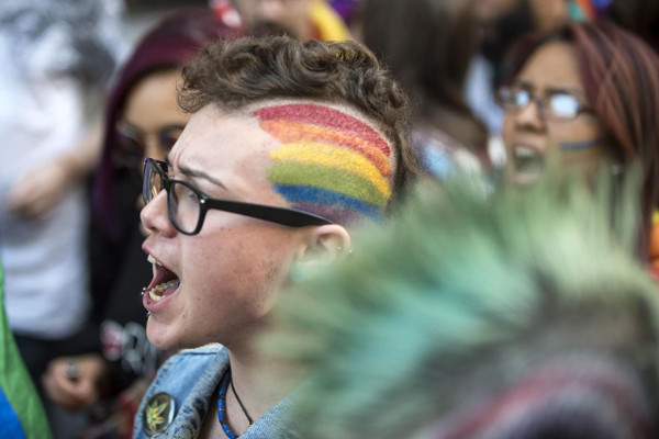 Imagen de una persona con la bandera arcoiris pintada en la cabeza
