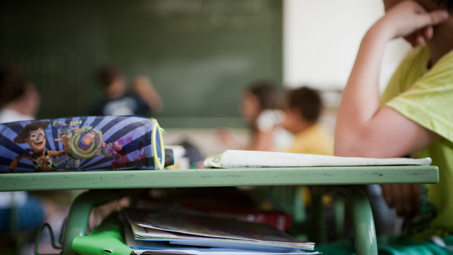 imagen de un estuche encima de una mesa de un aula