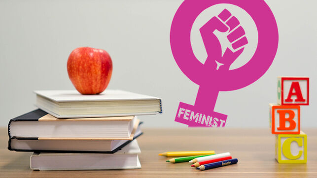 libros sobre una mesa y una manzana con un símbolo feminista