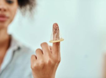 Una joven muestra cómo se pone un preservativo