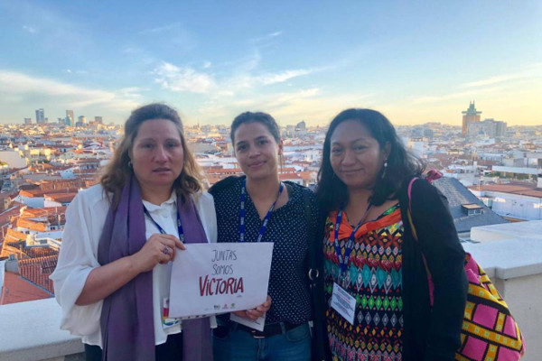 Tres mujeres con el cartel Juntas somos Victoria