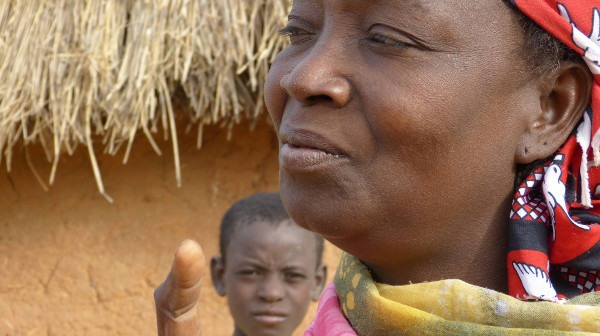 una mujer nigeriana delante de una cabaña