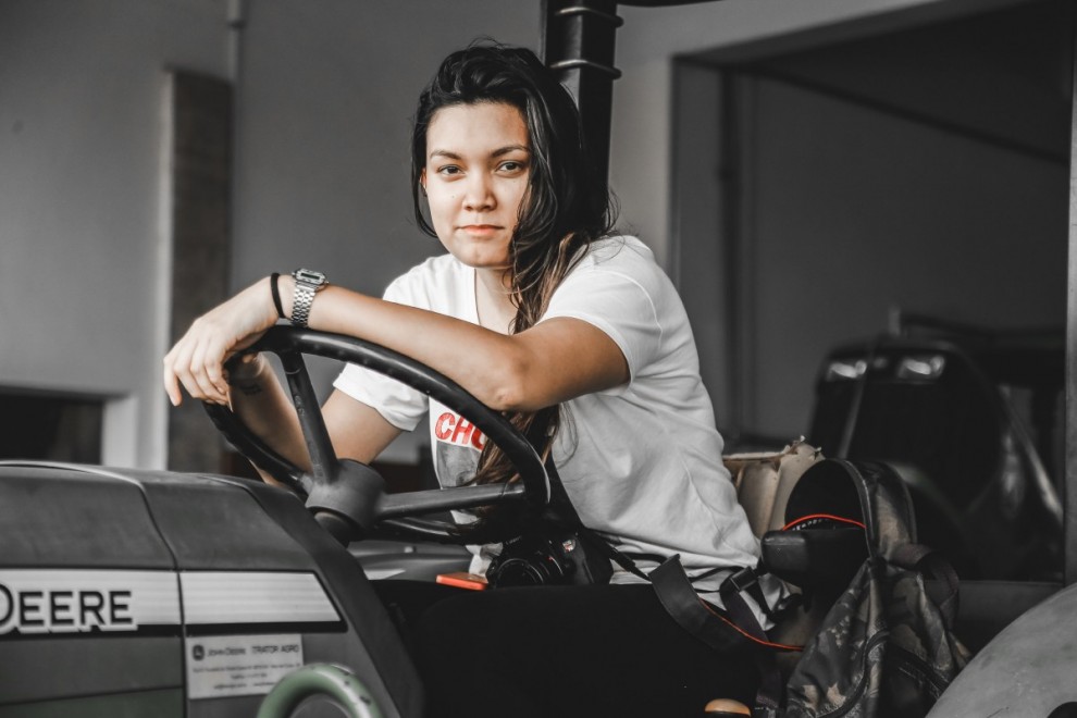 una joven subida en un tractor