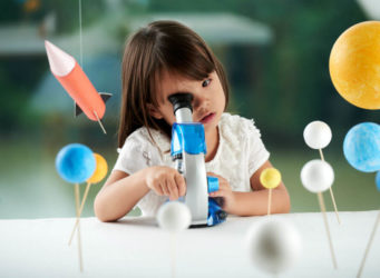 imagen de una niña mirando por un microscopio