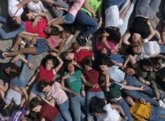 Fotograma del vídeclip con un grupo de chicas tumbadas en el suelo