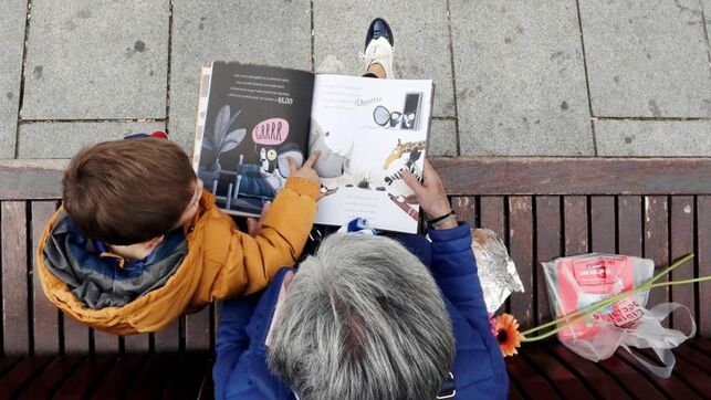 Una abuela leyendo un libro a su nieto