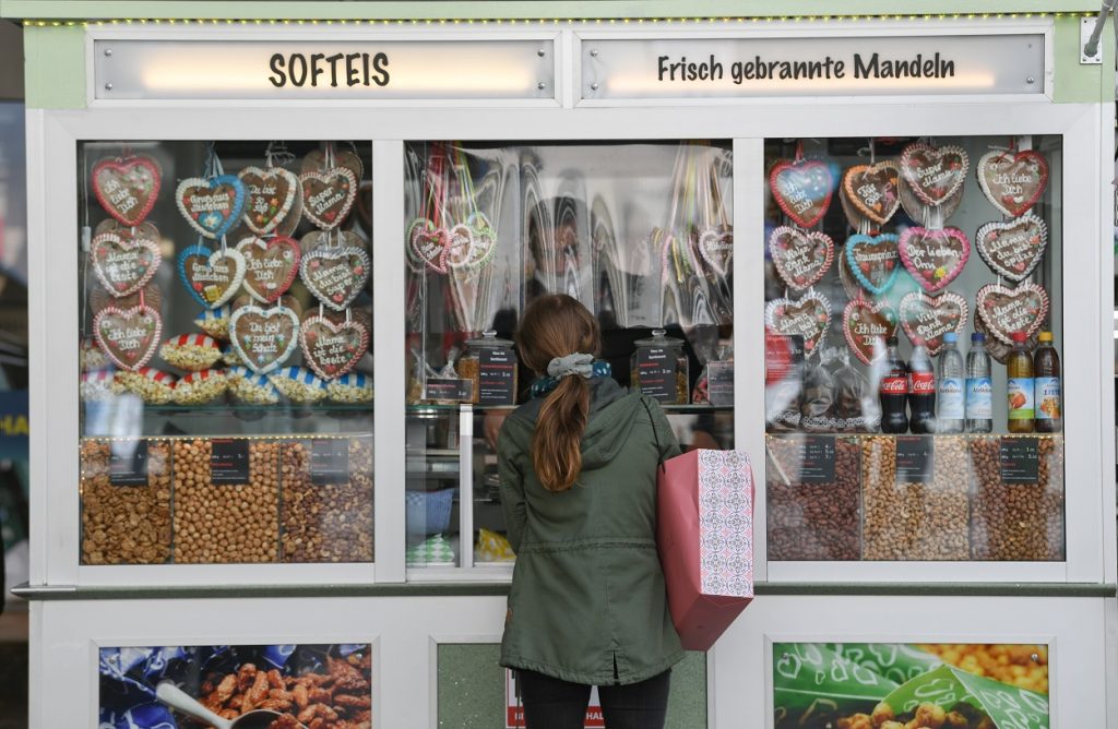 una mujer delante de un escaparate lleno de galletas en forma de corazón