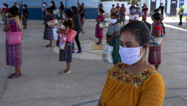 mujeres con mascarilla y manteniendo distancia en un patio