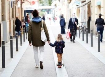 un niño y un adulto pasean por la calle