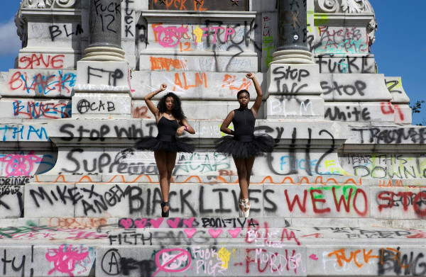 dos bailarinas de color protestan delante de un monumento en Virginia