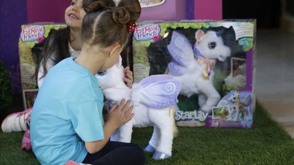 una niña juega con un unicornio