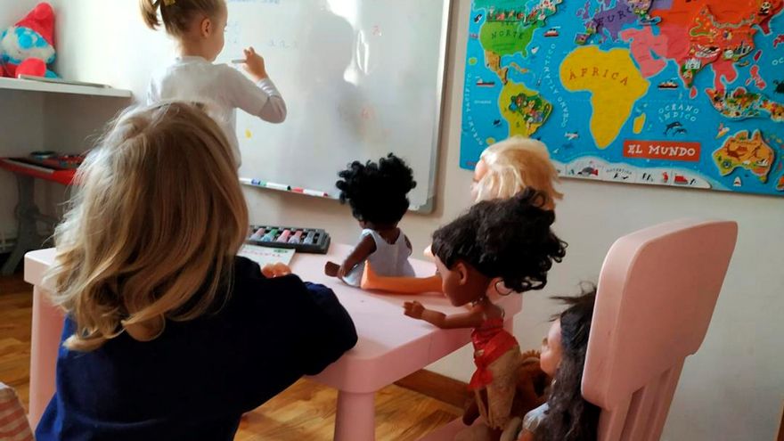 niñas en una escuela jugando con muñecas