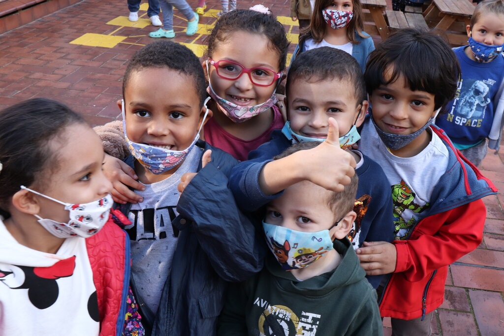 un grupo de niños y niñas en una clase con mascarillas