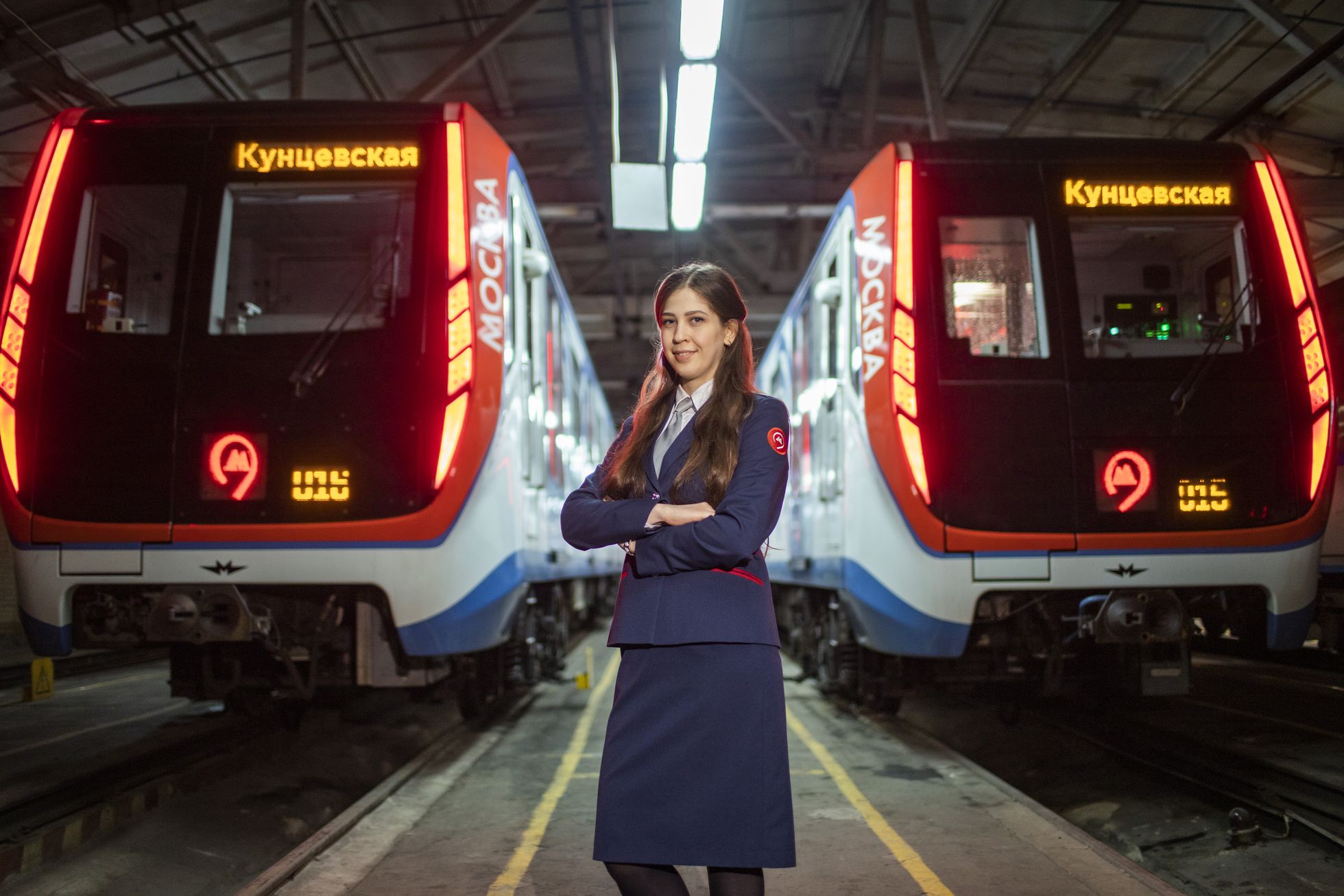 una de las mujeres maquinistas ante dos trenes