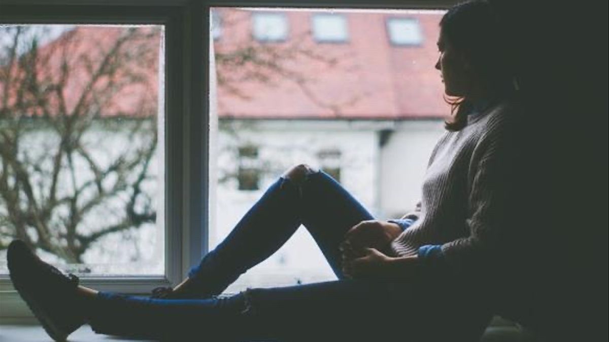 una mujer ante una ventana