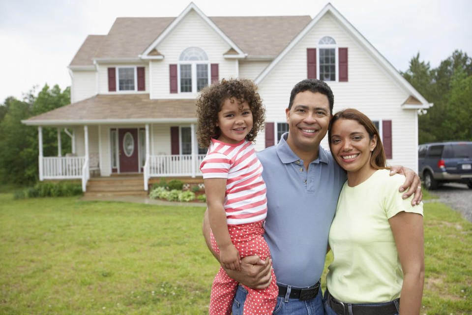 una familia ante una casa y un coche