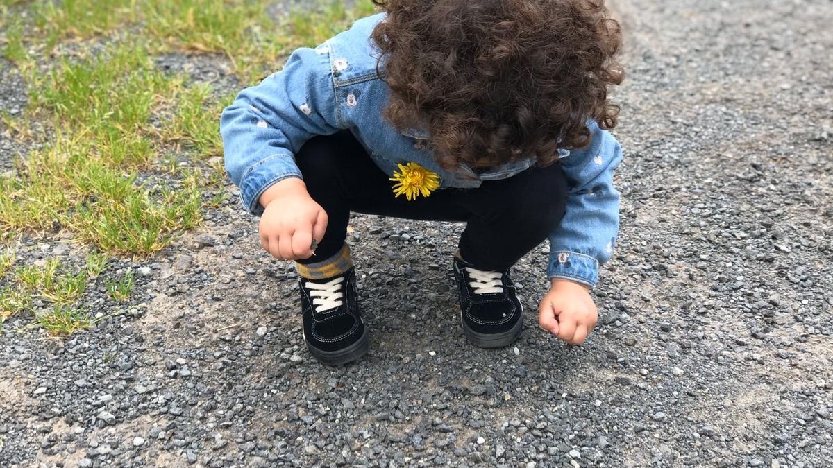 imagen de una niña agachada en un camino