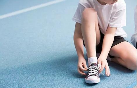 un niño se ata la zapatilla