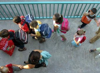 niñas y niños entrando en un colegio