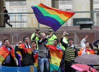 Imagen de manifestantes con una bandera arco iris