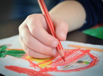 Imagen de la mano de un niño o niña dibujando