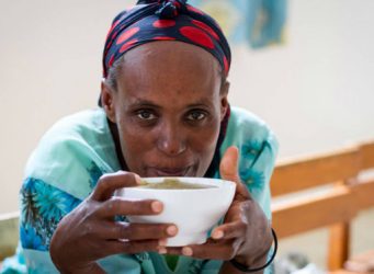 Imagen de una joven africana comiendo