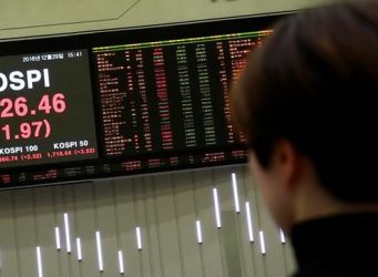 una joven mirando un rótulo en la Bolsa de Seúl