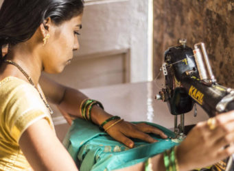 una mujer india cosiendo a máquina