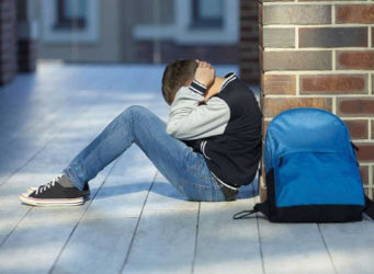 imagen de un joven sentado en el suelo con aspecto de agobiado