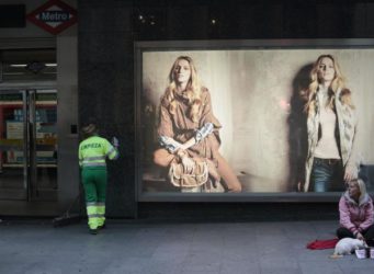 una mujer pidiendo delante de un escaparate con un gatito