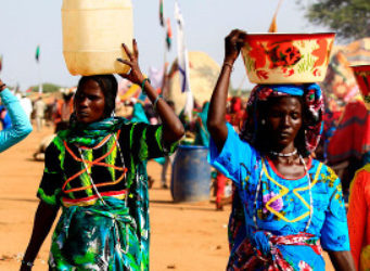 Unas mujeres de Darfur llevan agua