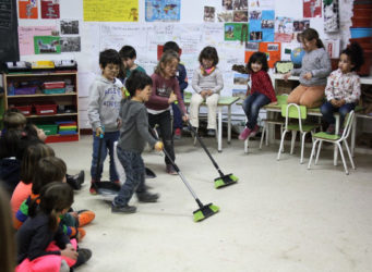 niños y niñas barriendo la clase