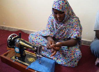 Imagen de una niña en un curso de costura en Mauritania